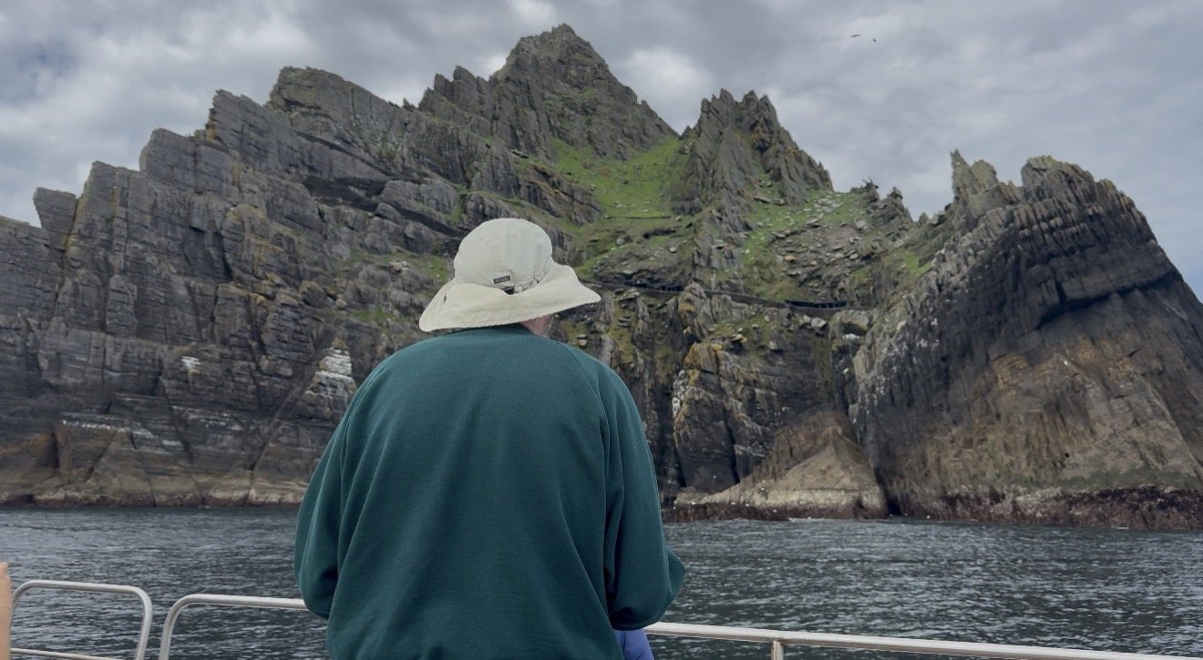 Passenger looking out at the Skellig cliffs from the boat